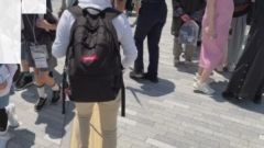 会場整備の係員が道を開けるよう呼び掛けている画像