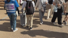 スーツケースの前を人が行きかう画像