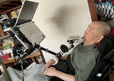 写真：マッチマウスでパソコンを操作する黒澤さん